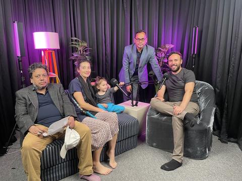 Podcast recording setup in Dhaka — group photo with hosts, studio lights, and microphones